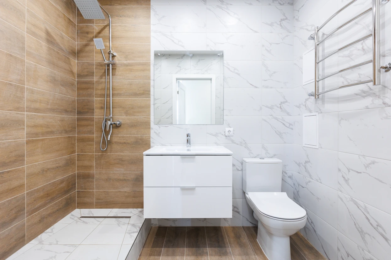 Salle de bain moderne avec douche à l'italienne, meuble vasque suspendu blanc, WC et sèche-serviettes