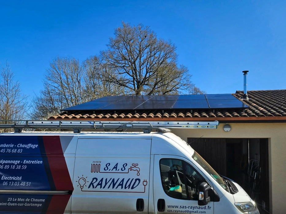 Photographie professionnelle en gros plan d'une main de technicien qualifié installant ou configurant un thermostat numérique moderne sur un mur blanc d'une maison résidentielle. Le technicien porte des vêtements professionnels. L'arrière-plan montre un intérieur résidentiel clair. La mise au point est nette sur le thermostat et le travail d'installation, mettant l'accent sur la qualité professionnelle et l'expertise en chauffage.