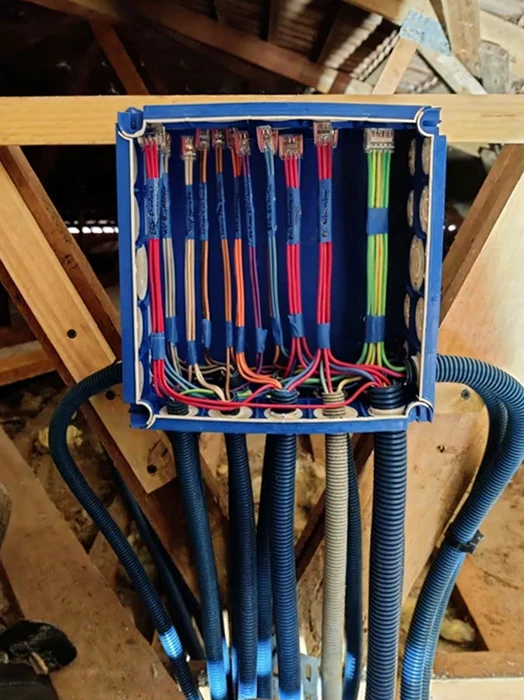 Installation d'une pompe à chaleur moderne dans un sous-sol de maison : vue en gros plan de l'unité intérieure compacte fixée au mur, avec ses tuyaux de raccordement isolés, montrant la qualité professionnelle de l'installation. Lumière naturelle douce, environnement résidentiel et fonctionnel.